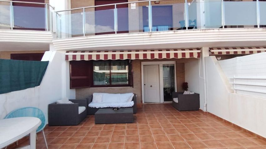 Terraza al aire libre con toldo y mobiliario, antes de la reforma